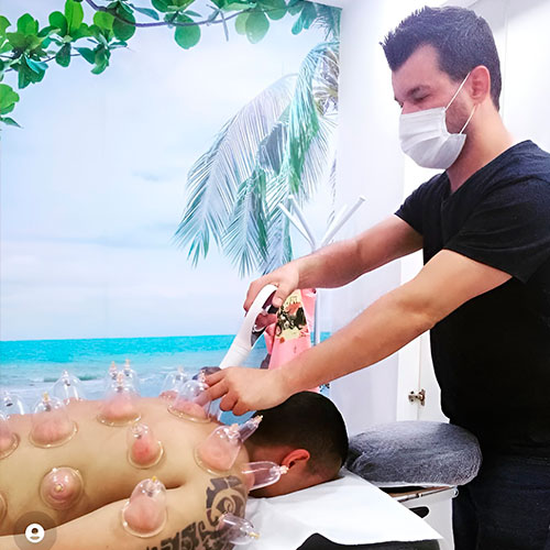 Profissional Wagner aplicando a Ventosaterapia no cliente.